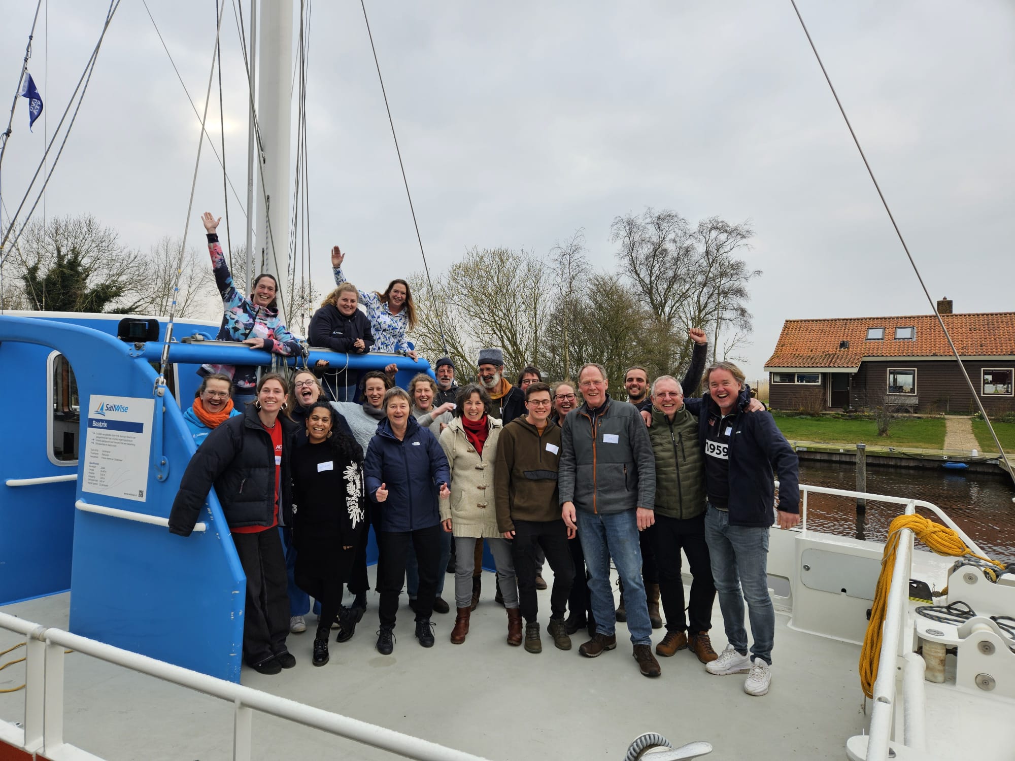 Het team SailWse 2024 staat enthousiast op de catamaran Beatrix